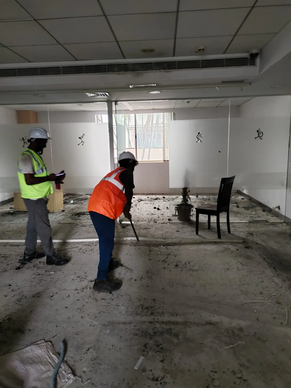 Deconstruction technicians dismantling modern modular workstation systems inside a Guindy commercial building.